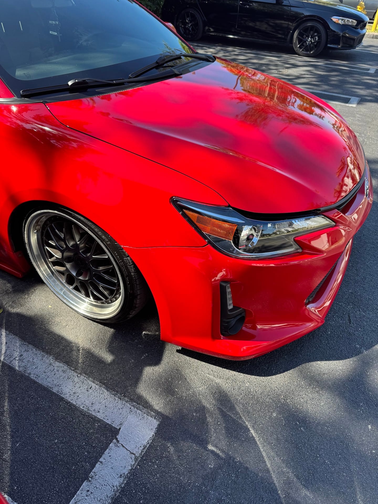 Close view of the red Scion tC's front fender and headlight after repair
